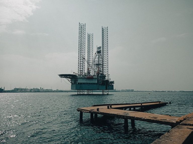 Offshore oil platform in urban harbor, showcasing industrial scenery and oceanic platform structure.