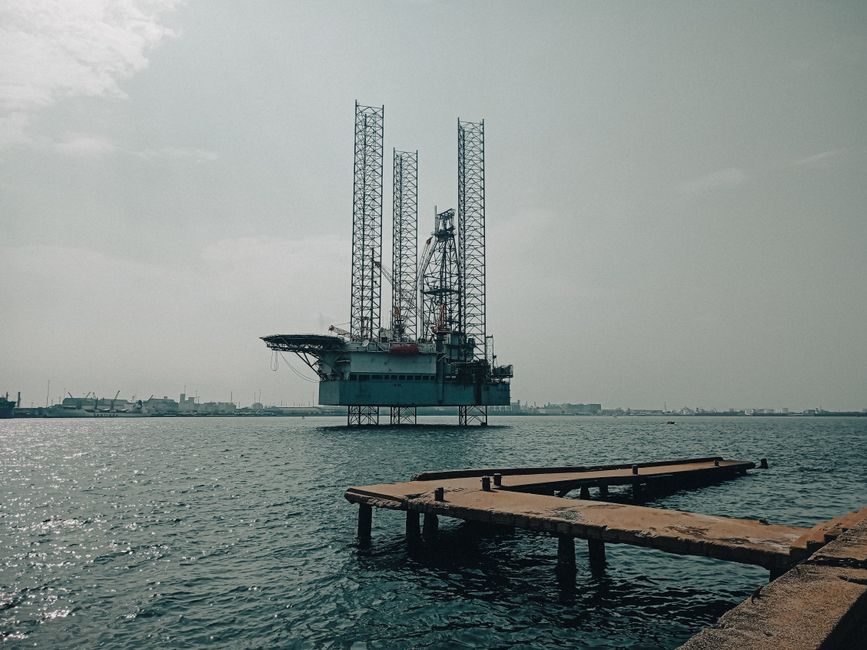 Offshore oil platform in urban harbor, showcasing industrial scenery and oceanic platform structure.