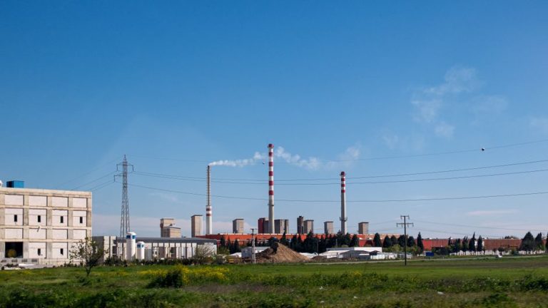 A large industrial facility with smokestacks and clear skies, illustrating industrialization.