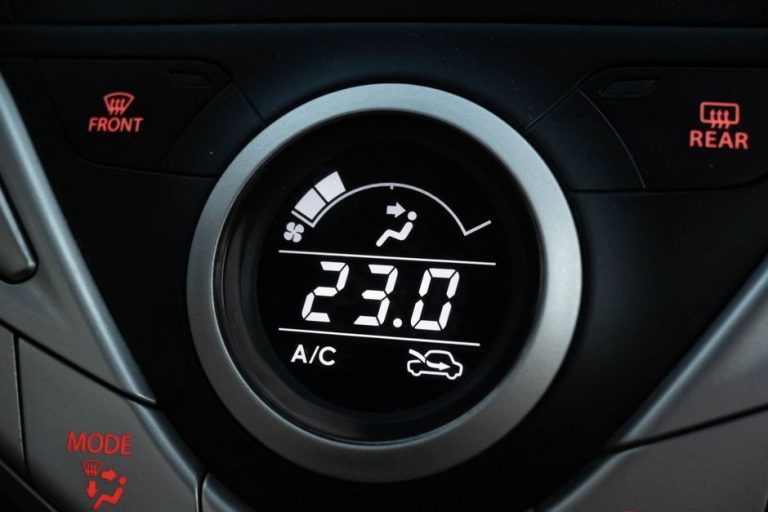 Close-up view of a car climate control system set to 23 degrees Celsius.