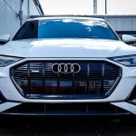 Sleek white Audi E-Tron SUV captured outdoors with a modern design.
