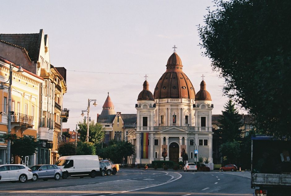 View of a historic church and surrounding architecture in a European city at sunset.