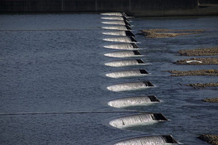 A series of cascading waterfalls over dam structures, showcasing flowing water and stone formations.