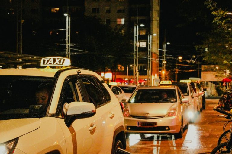 Taxis lined up under streetlights in Salzburg, Austria, captured at night.