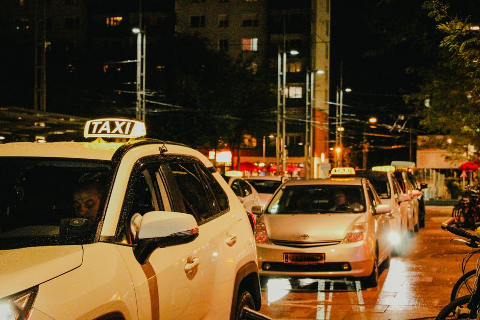Taxis lined up under streetlights in Salzburg, Austria, captured at night.