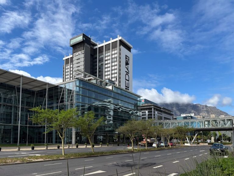 Modern buildings in Cape Town with Table Mountain backdrop under a clear sky.