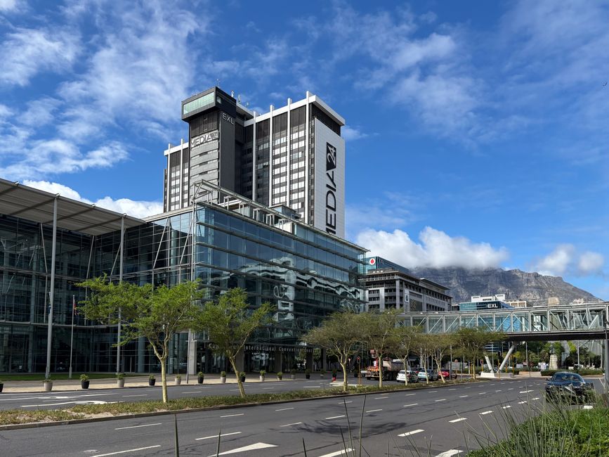 Modern buildings in Cape Town with Table Mountain backdrop under a clear sky.