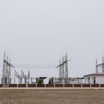 An industrial power station under a clear sky, showcasing electrical infrastructure and technology.