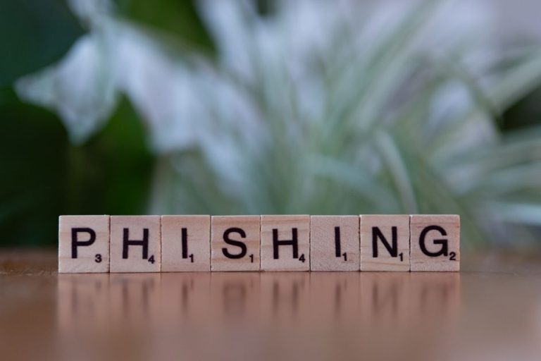 Wooden tiles spelling 'phishing' highlight cybersecurity themes.