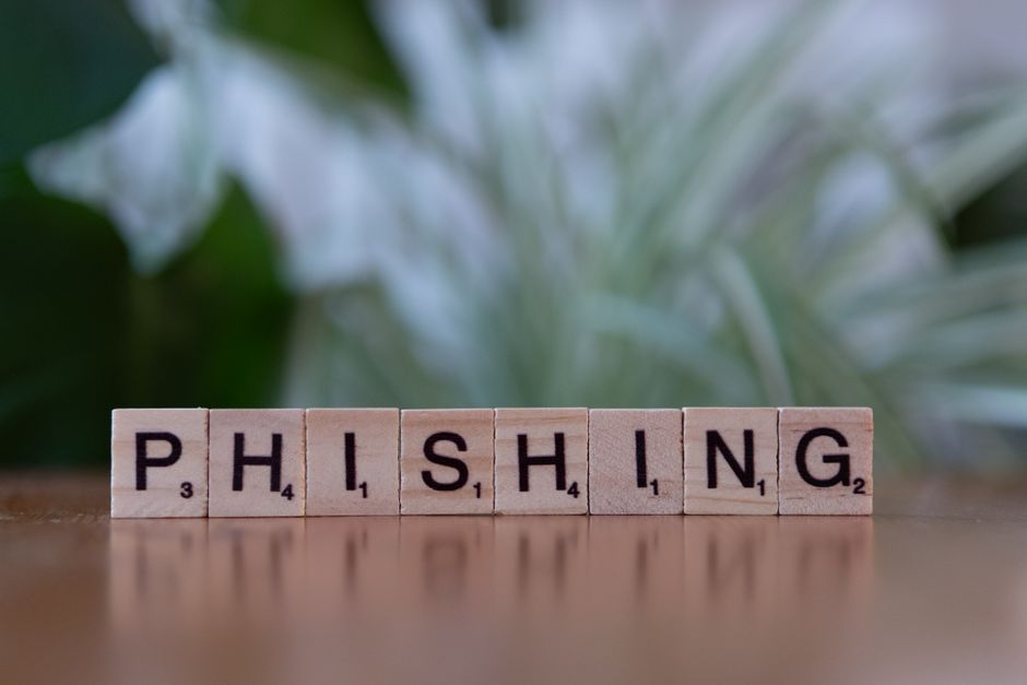 Wooden tiles spelling 'phishing' highlight cybersecurity themes.