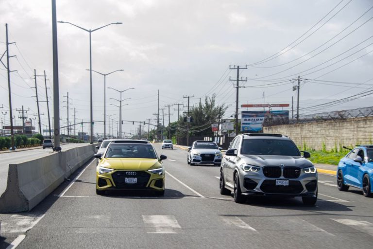 A variety of cars on a busy highway in Jamaica, showcasing urban travel.