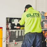 A technician from Elite Power Group installing a home battery system indoors in New South Wales, Australia.