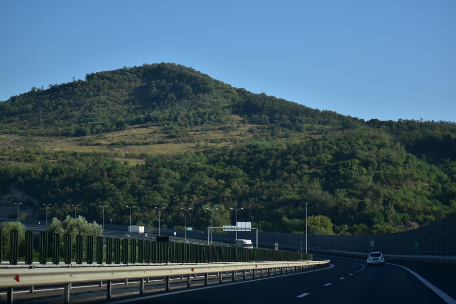 A scenic highway view in Romania, showcasing lush green hills on a sunny day.