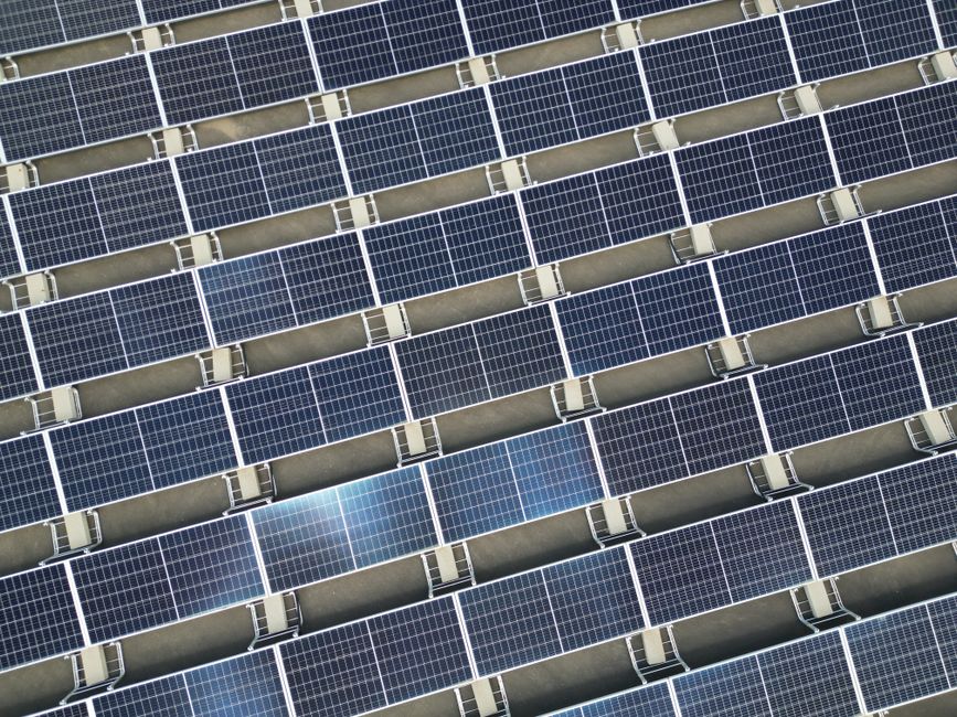 Array of solar panels in grid layout viewed from above promoting renewable energy