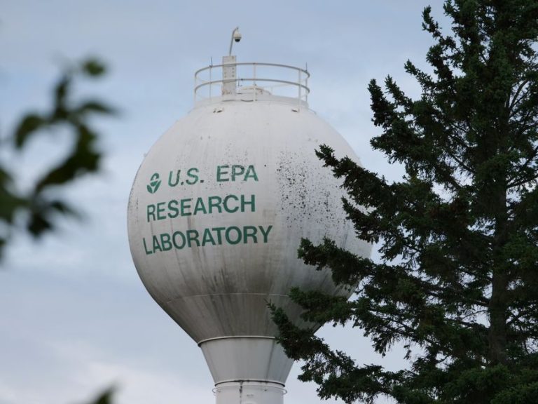 U.S. EPA Research Laboratory water tower with trees in view.