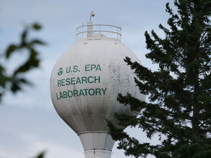 U.S. EPA Research Laboratory water tower with trees in view.