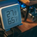 Close-up of a digital hygrometer showing temperature and humidity indoors.
