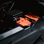 Detailed view of an electric car battery inside a vehicle's engine compartment, highlighting sustainable technology.