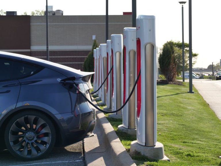 Electric car plugged into a row of charging stations, showcasing modern EV infrastructure.