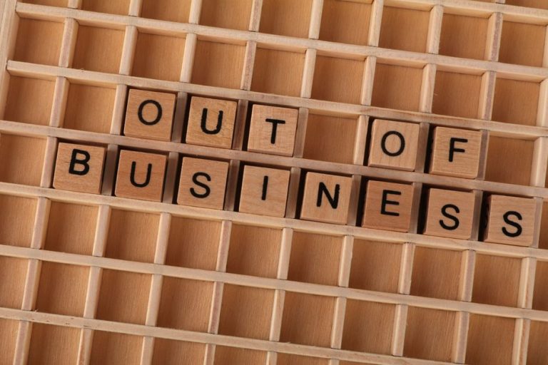 Wooden blocks spelling out 'Out Of Business' symbolize closure or economic downturn.