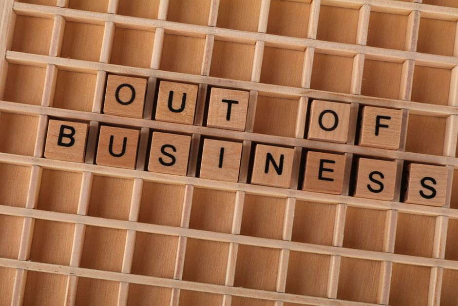 Wooden blocks spelling out 'Out Of Business' symbolize closure or economic downturn.