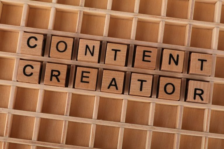 Wooden block letters spelling 'Content Creator' on a grid background. Ideal for digital marketing themes.