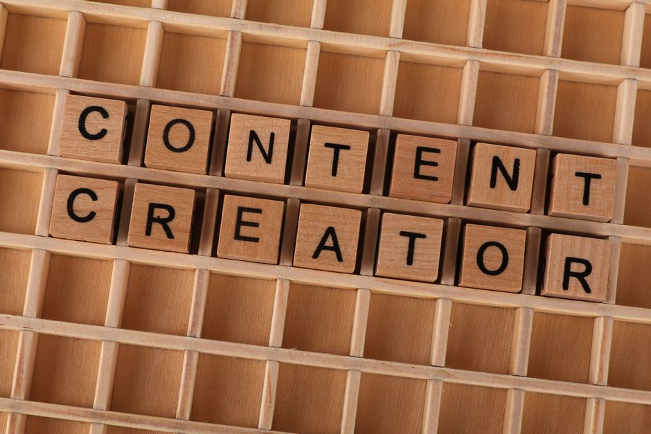 Wooden block letters spelling 'Content Creator' on a grid background. Ideal for digital marketing themes.