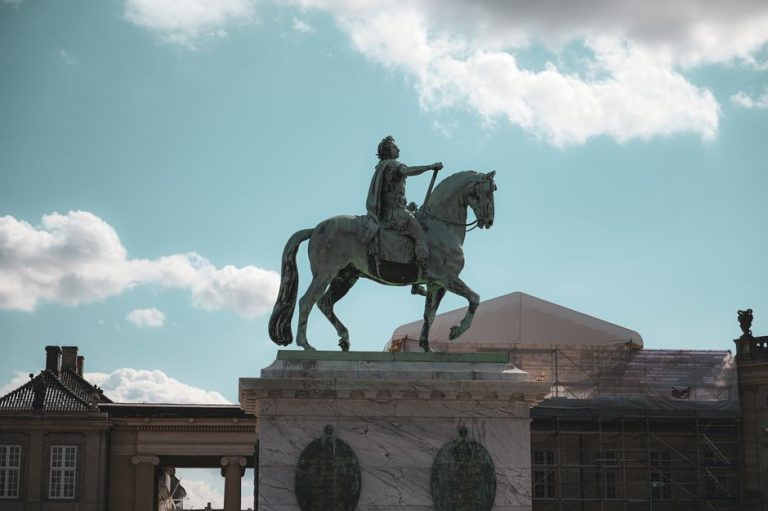 Equestrian statue of King Frederik V at Amalienborg, Copenhagen under a bright sky.