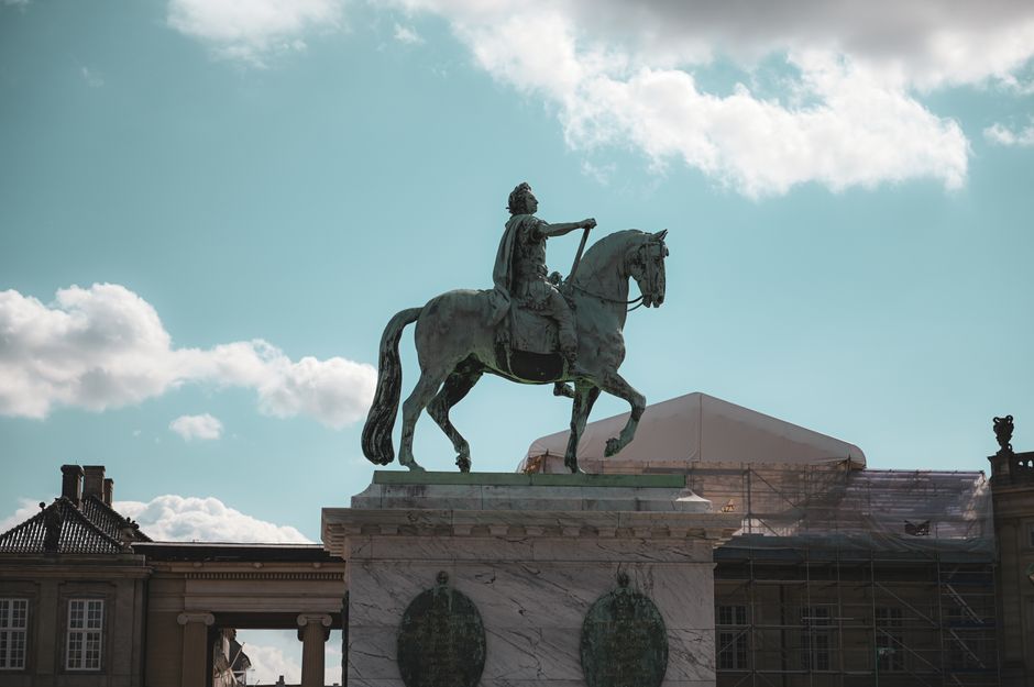 Equestrian statue of King Frederik V at Amalienborg, Copenhagen under a bright sky.