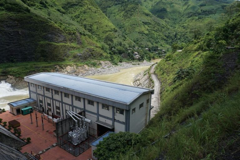 Scenic view of a hydroelectric power plant amidst lush limestone mountains in Vietnam.