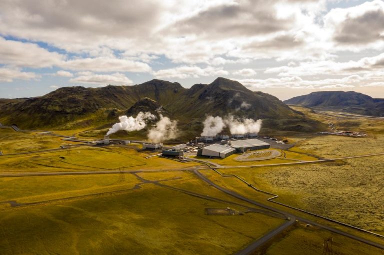Aerial view of Hellisheidi geothermal power plant with mountains and steam in Iceland