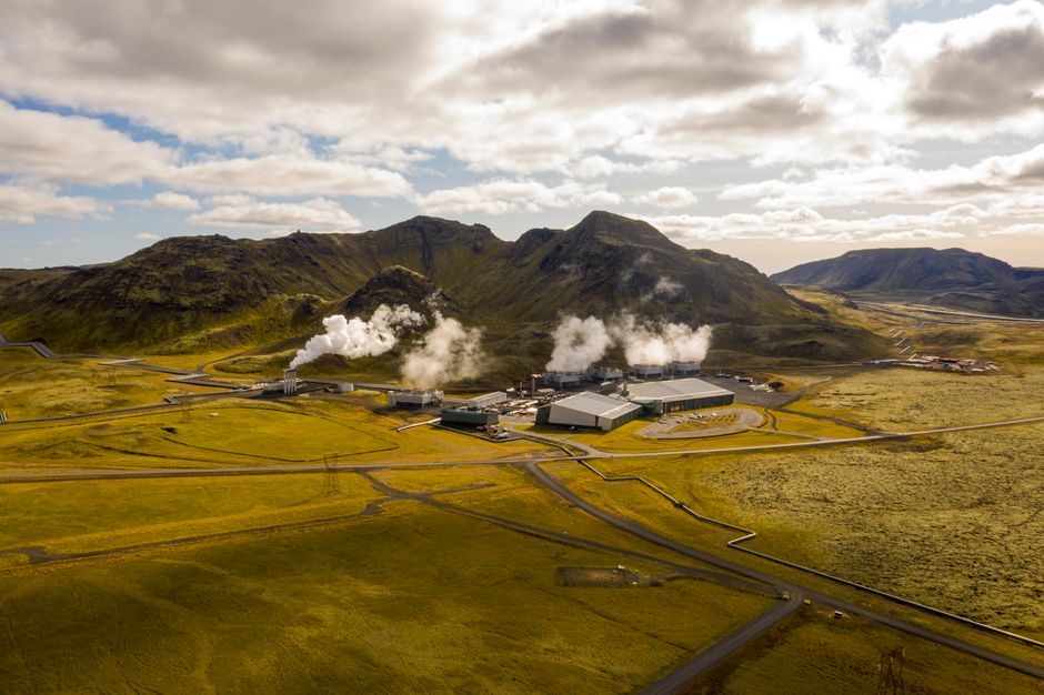 Aerial view of Hellisheidi geothermal power plant with mountains and steam in Iceland