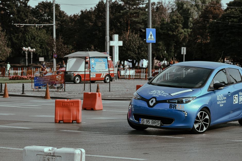 Blue car driving on asphalt race track in city center while racing rally