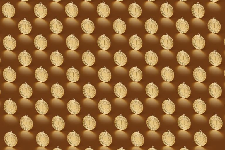 Multiple gold medals arranged in a repeating pattern on a brown backdrop.