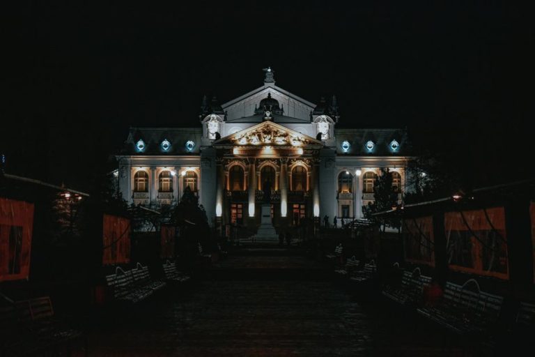 The National Theatre in Romania beautifully illuminated at night showcasing its grand architecture.