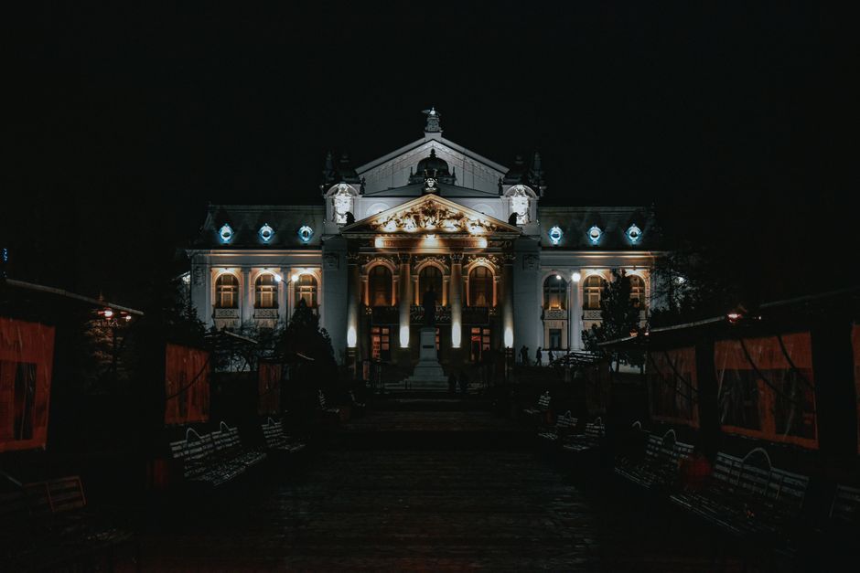 The National Theatre in Romania beautifully illuminated at night showcasing its grand architecture.