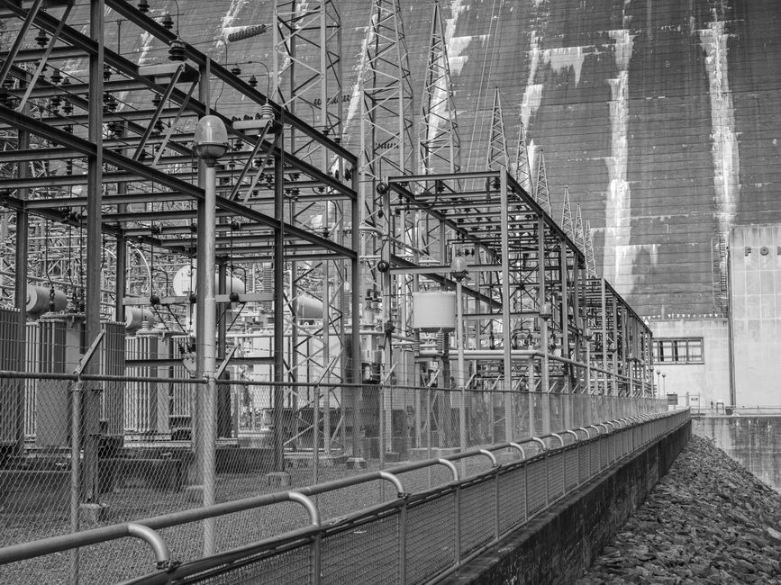 Grayscale image of an industrial electric substation with steel towers and electric lines.