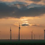 Scenic view of wind turbines at sunset in Romania, showcasing alternative energy sources and sustainability.