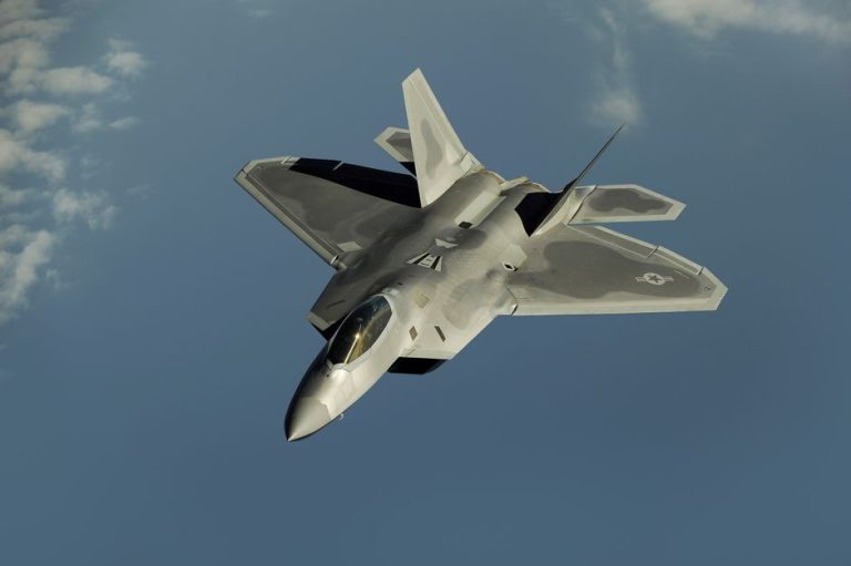 Powerful military aircraft soaring against a calm blue sky.