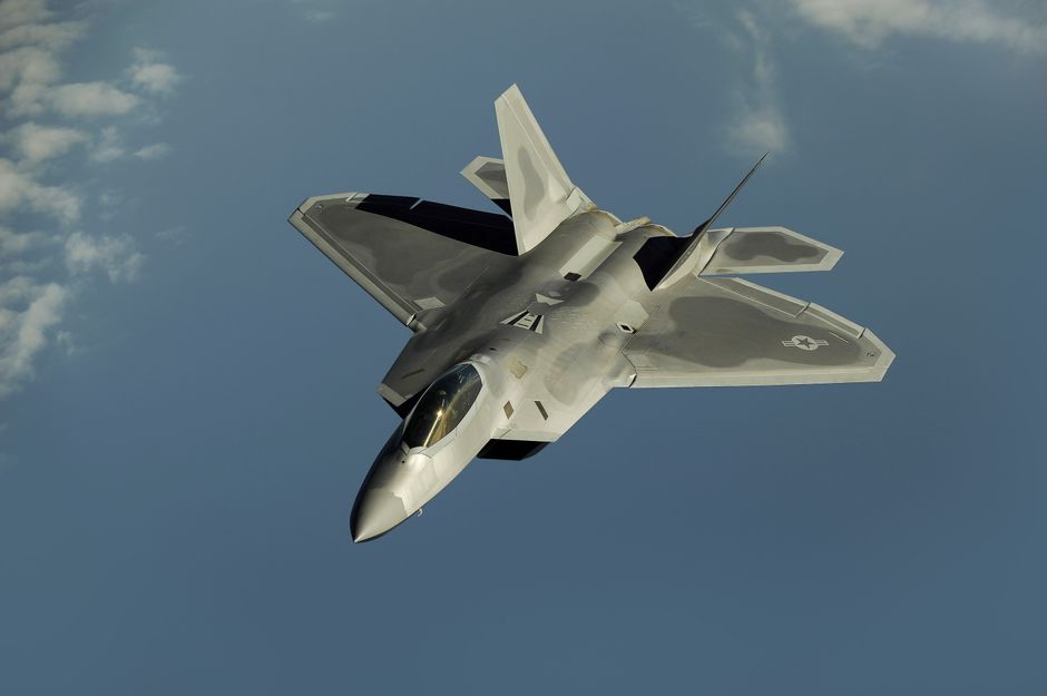 Powerful military aircraft soaring against a calm blue sky.
