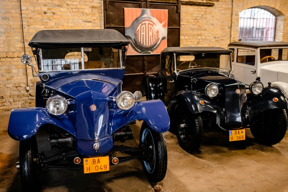 Capture of classic Tatra automobiles displayed inside a historic building.