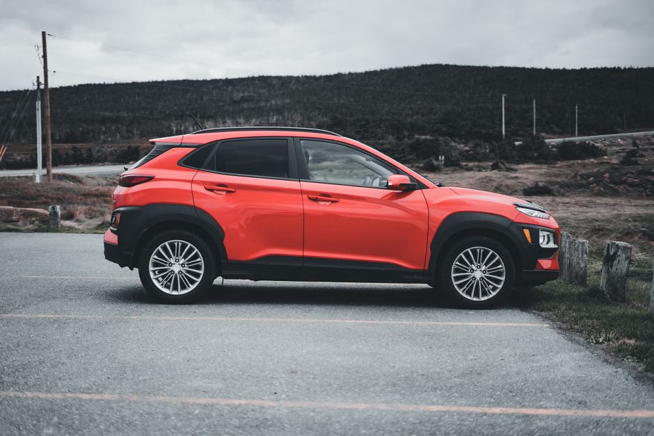Red SUV parked outdoors on a cloudy day, showcasing sleek design and vibrant color.