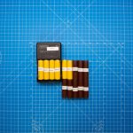 Top view of batteries on a blue grid design surface with a charger, showcasing organization and technology.