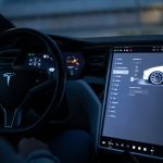 Tesla car interior showcasing advanced touchscreen display and steering controls.