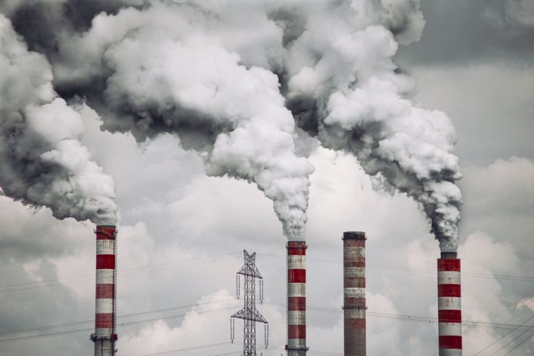 Smoke billows from factory chimneys in Konin, Poland, highlighting pollution and environmental impact.