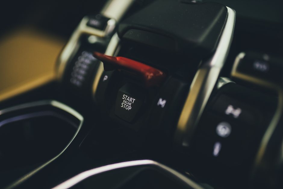 Detailed view of the start engine button in a Lamborghini Urus interior, showcasing modern luxury design.
