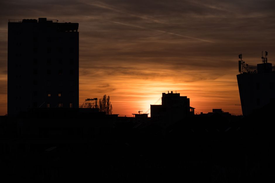 Silhouette of Bucharest cityscape against a vibrant sunset sky, capturing the urban skyline beautifully.