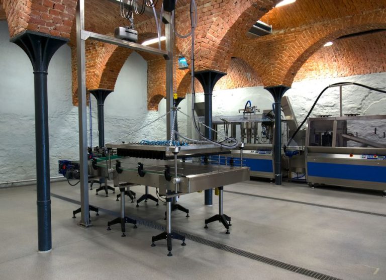 Contemporary factory interior with machinery and distinctive brick arch architecture.