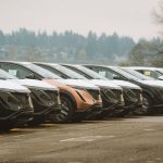 Rows of sleek electric cars parked outdoors, showcasing automotive design and innovation.