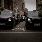 Black taxis line up on a London street showcasing modern urban transportation.